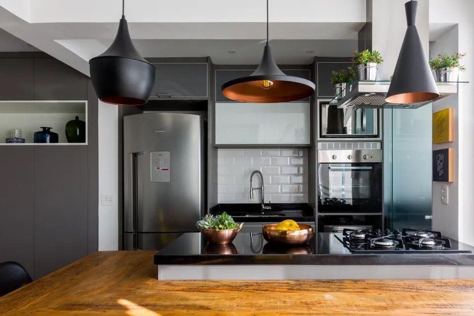 Uma cozinha com mesa de madeira, eletrodomésticos de aço inoxidável, geladeira e fogão.