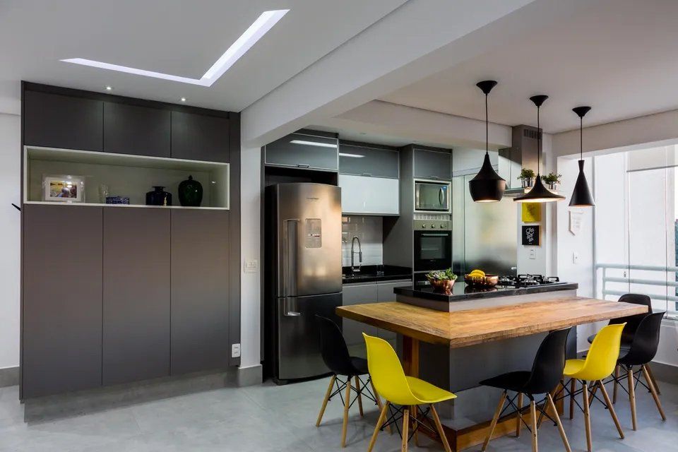 Uma cozinha com uma grande mesa de madeira e cadeiras amarelas