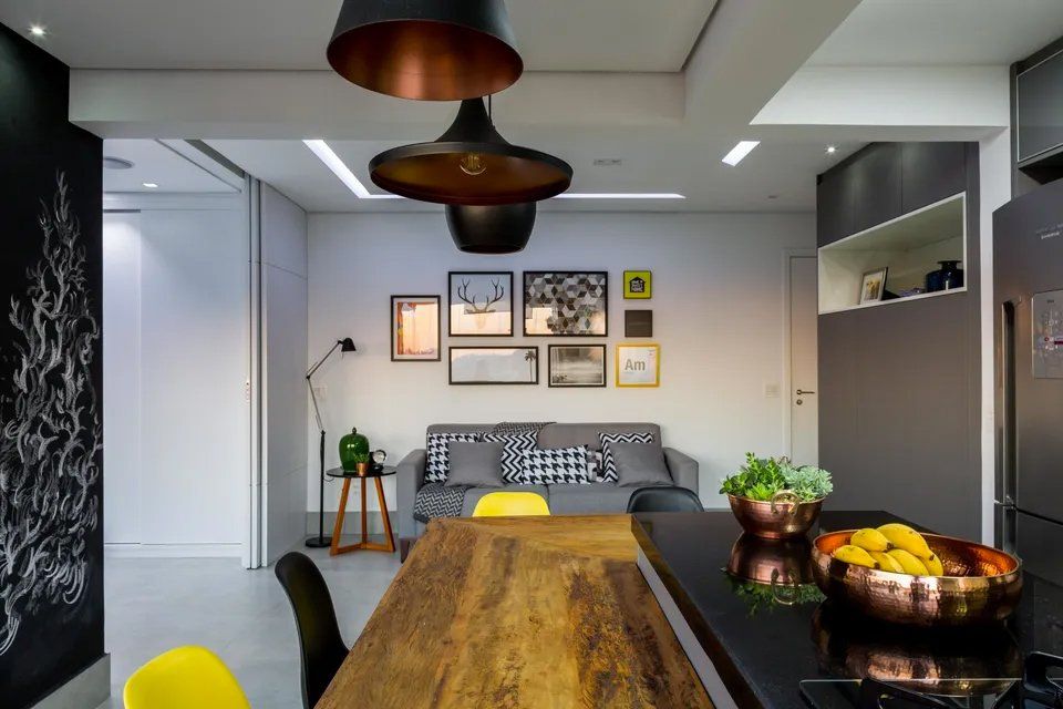 Uma sala de estar com mesa e cadeiras de madeira e um sofá.