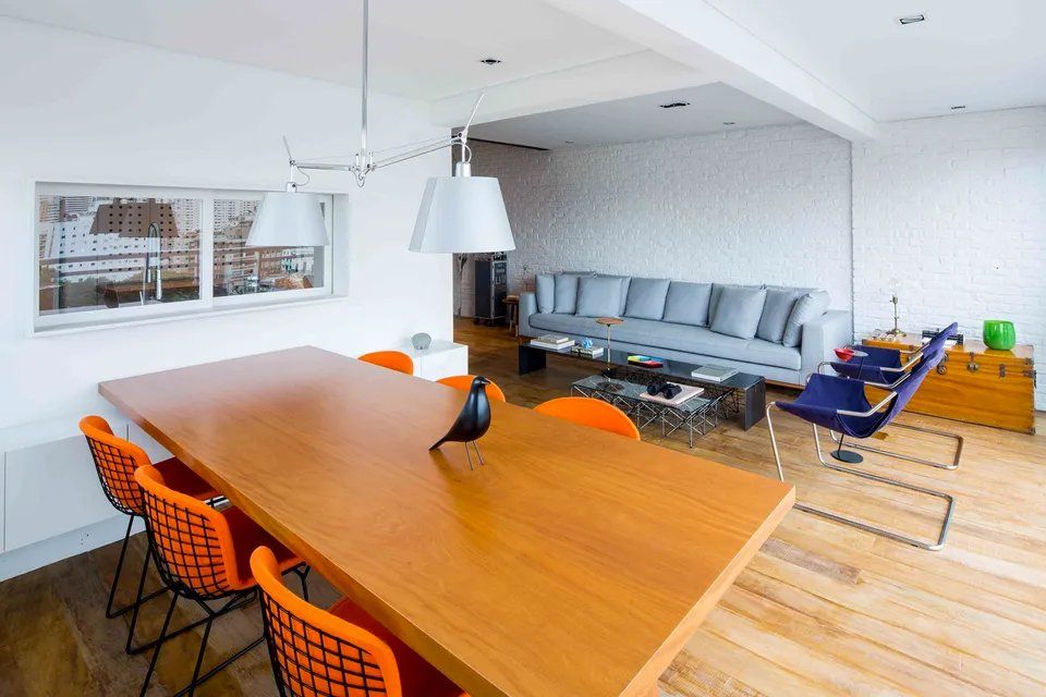 Uma sala de estar com mesa e cadeiras de jantar e um sofá.