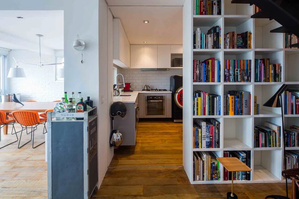 A cozinha e a sala de jantar são separadas por uma estante repleta de livros.