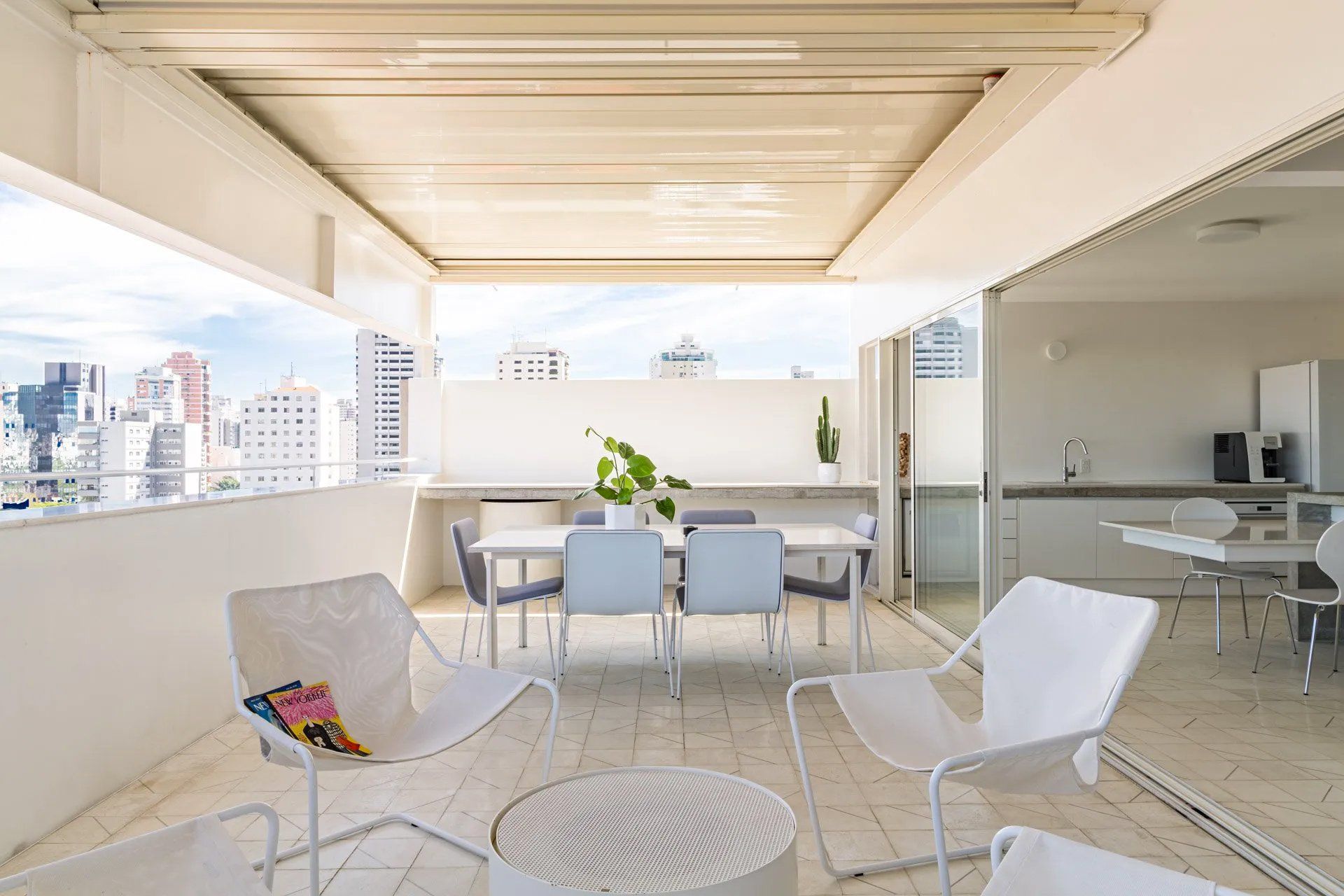 Há mesa e cadeiras na varanda com vista para a cidade.