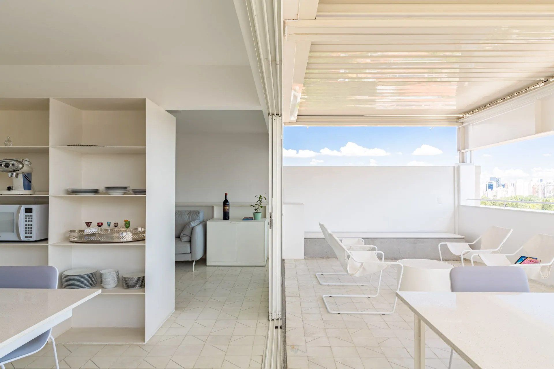 Uma sala de estar com mesa e cadeiras e varanda