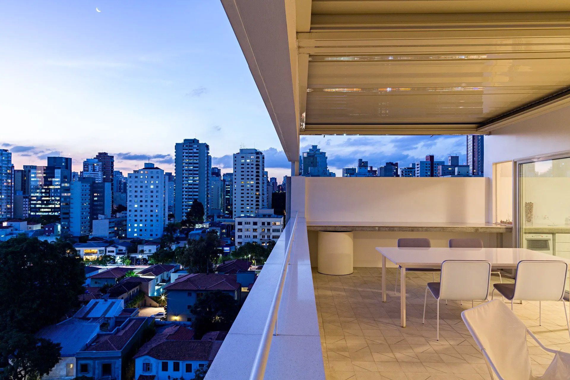 Uma varanda com vista para uma cidade à noite