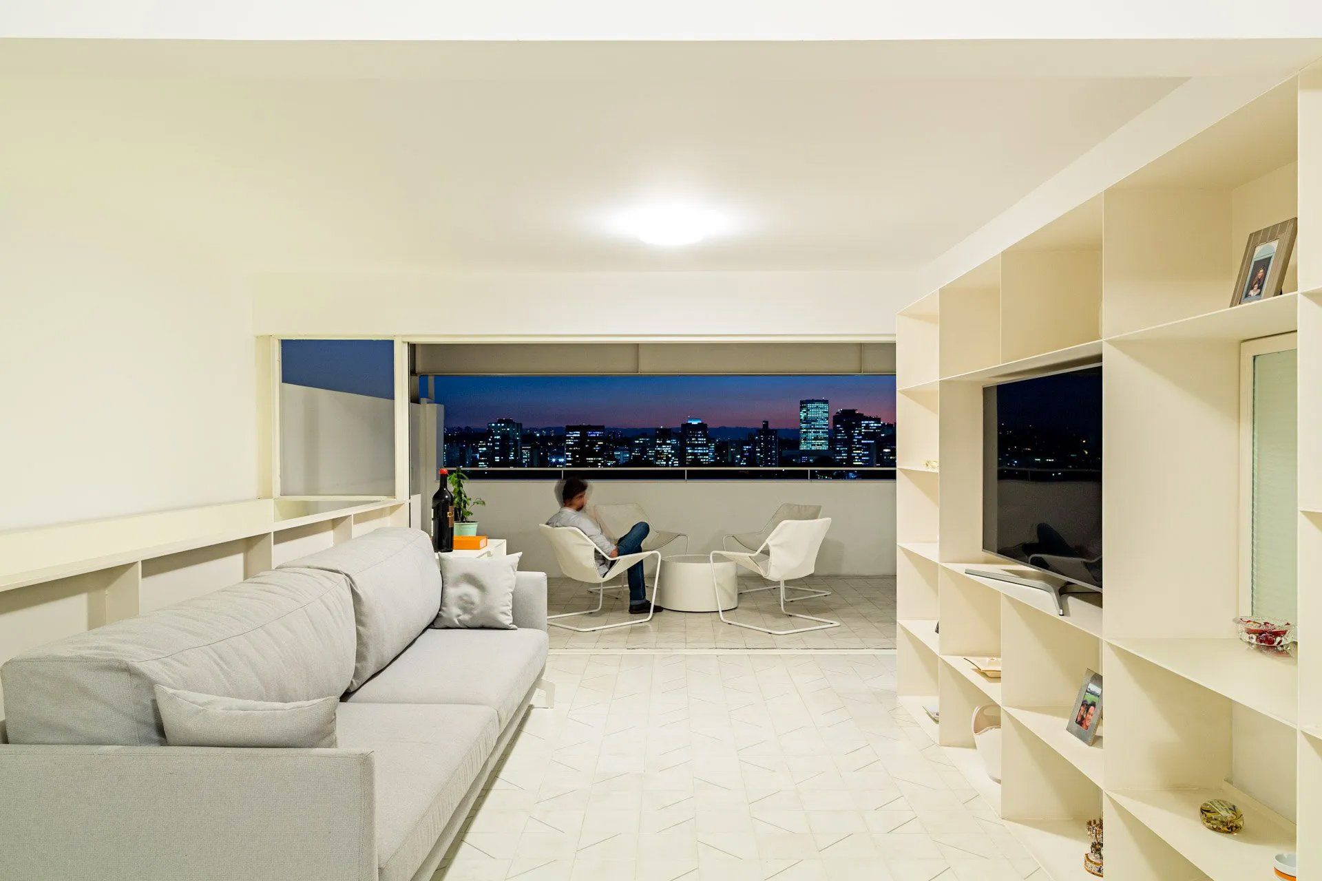 Uma sala de estar com sofá e cadeiras e vista para a cidade