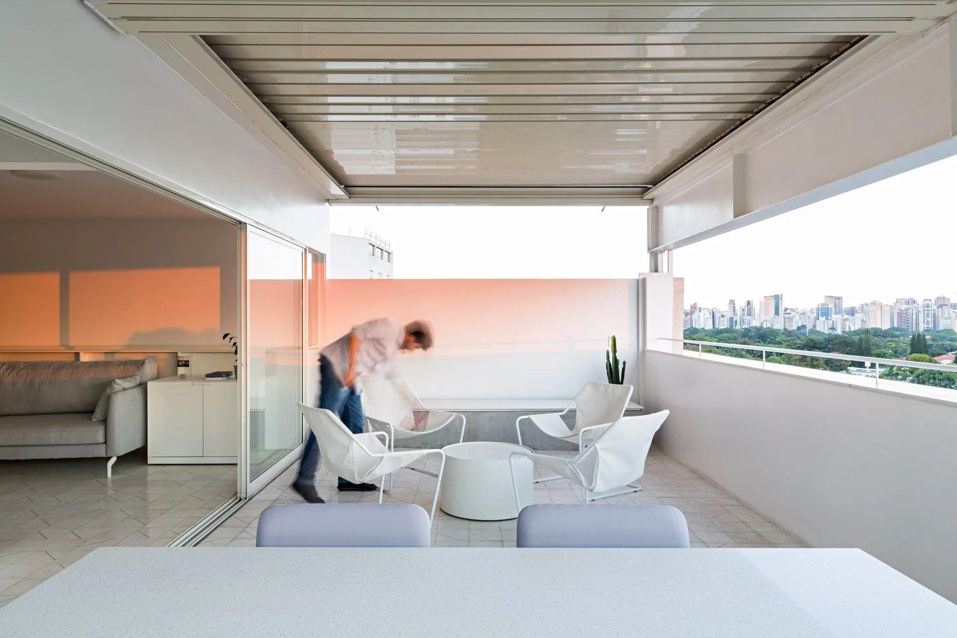 Um homem está parado em uma varanda com vista para a cidade.