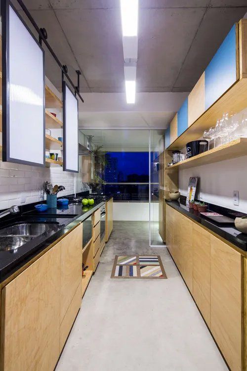 Uma cozinha com armários de madeira e bancadas pretas