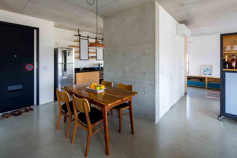 Há uma mesa de jantar e cadeiras no meio da sala.