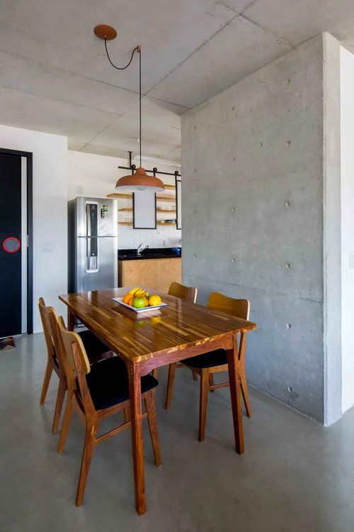 Uma sala de jantar com mesa e cadeiras de madeira.