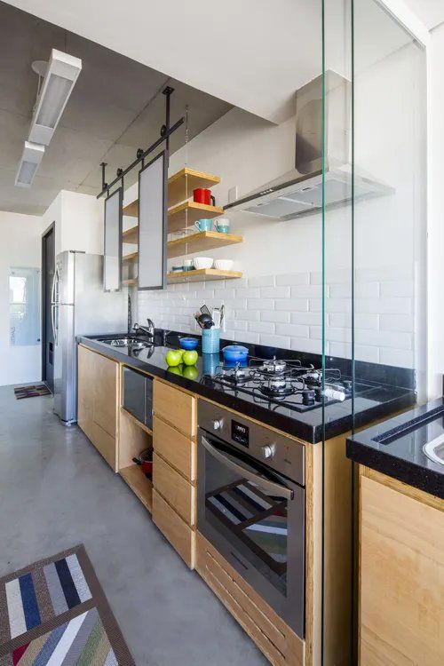 Uma cozinha com eletrodomésticos de aço inoxidável e armários de madeira