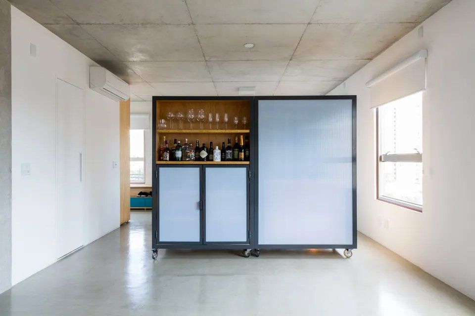 Uma sala com uma porta de vidro deslizante e uma prateleira com garrafas de vinho.