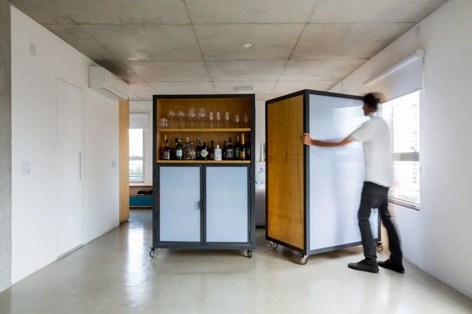 Um homem está empurrando um armário em uma sala.