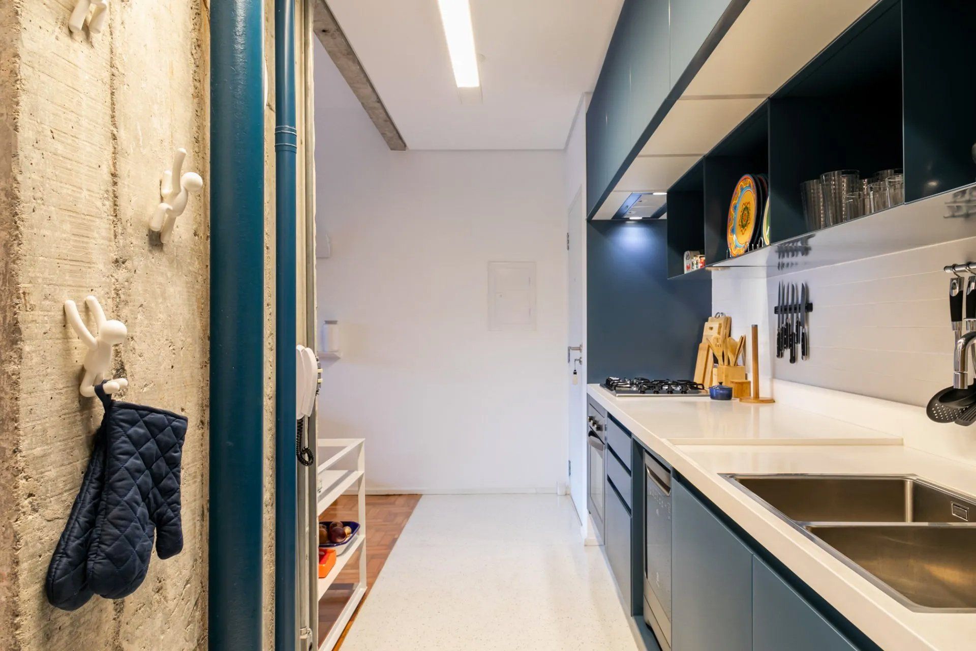 Uma luva de forno azul está pendurada em um gancho na cozinha.