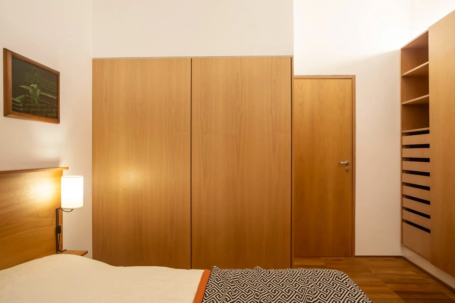 Um quarto com uma cama e uma porta de madeira