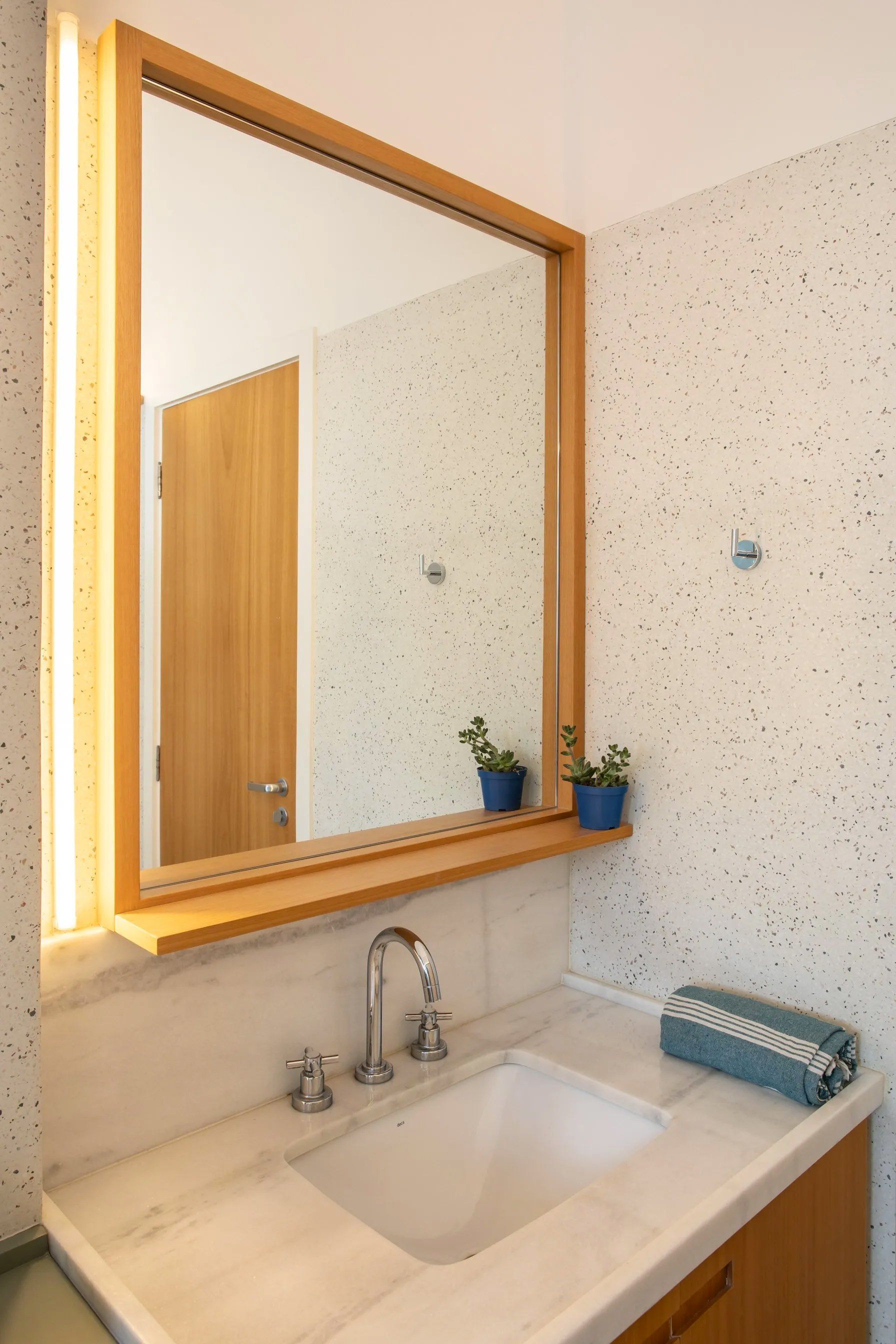 Uma pia de banheiro com um grande espelho acima.