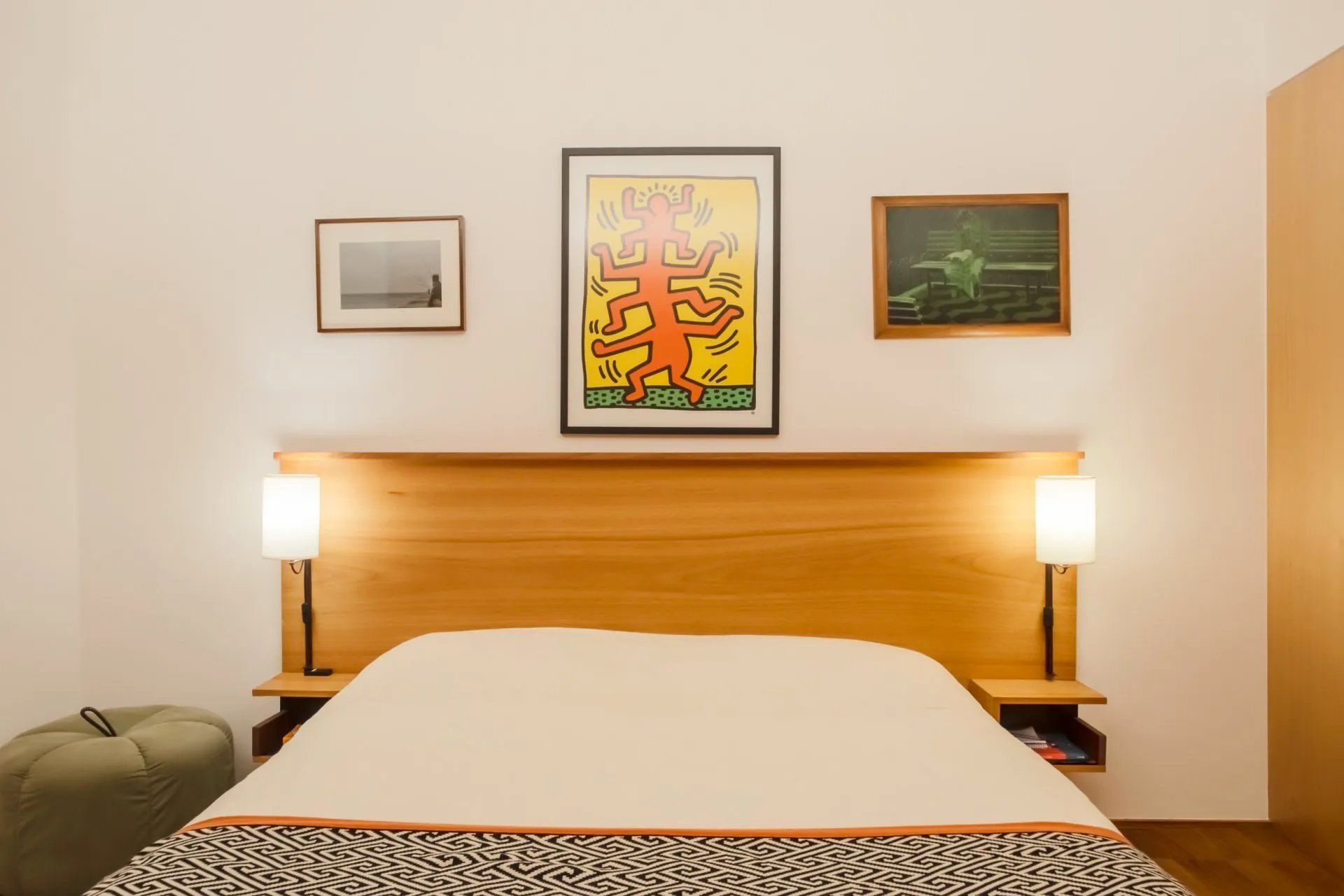 Um quarto com uma pintura na parede acima da cama