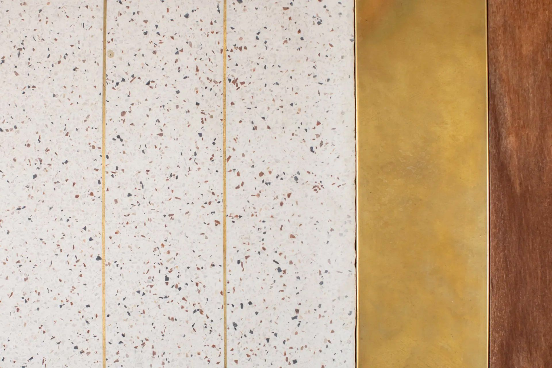 Um close de uma parede com três tipos diferentes de azulejos e madeira.