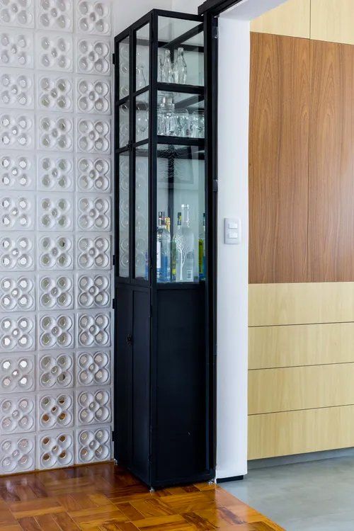 Há um armário de vidro no meio da sala.