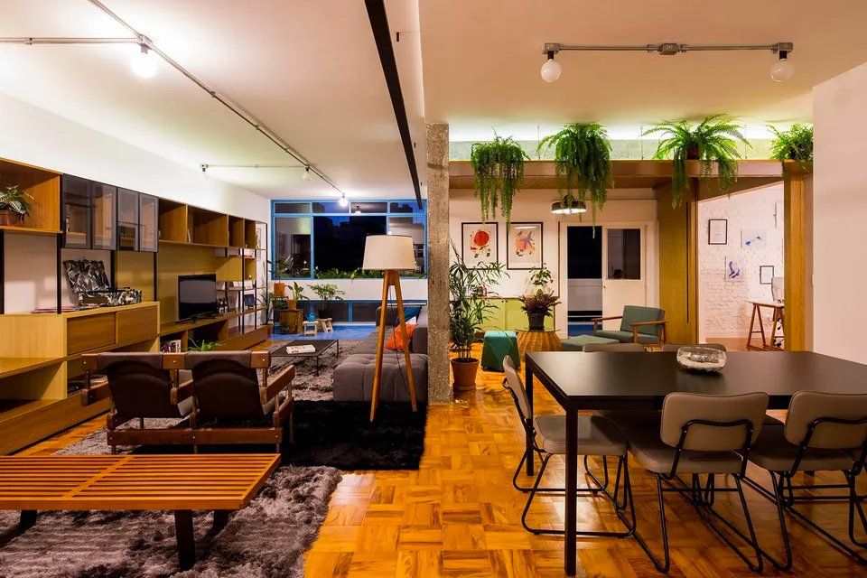 Uma sala de estar com mesa e cadeiras e uma sala de jantar com mesa e cadeiras.