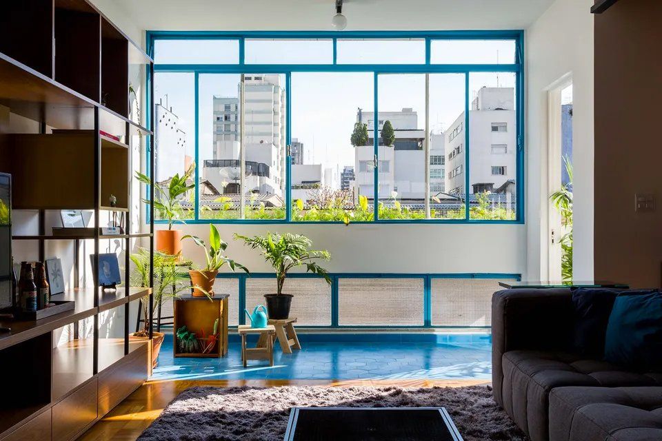 Uma sala com uma grande janela e um sofá.