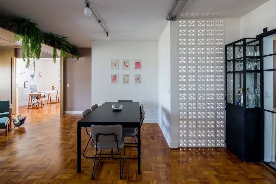 Uma sala de jantar com mesa e cadeiras e piso de madeira.