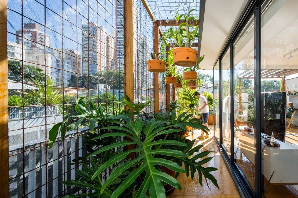 Uma varanda repleta de plantas e portas de correr de vidro.