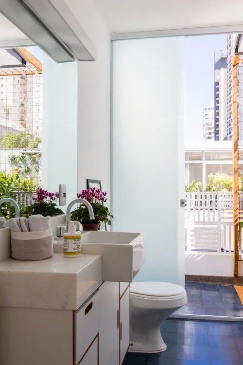 Um banheiro com vaso sanitário, pia e espelho