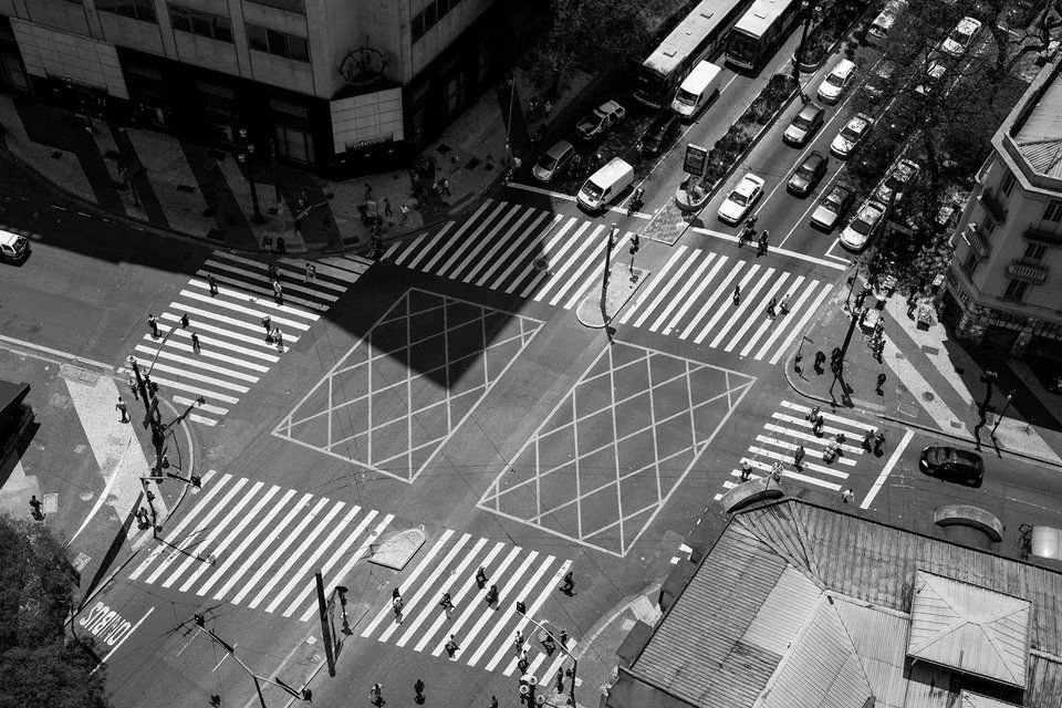 Uma foto em preto e branco de um cruzamento movimentado