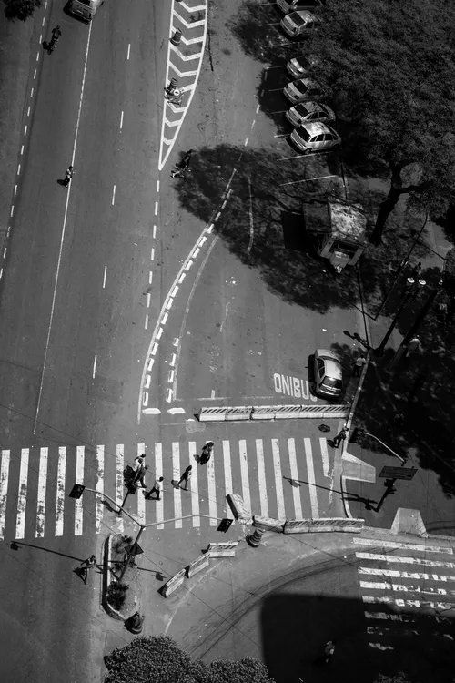 Uma foto em preto e branco de pessoas atravessando uma rua