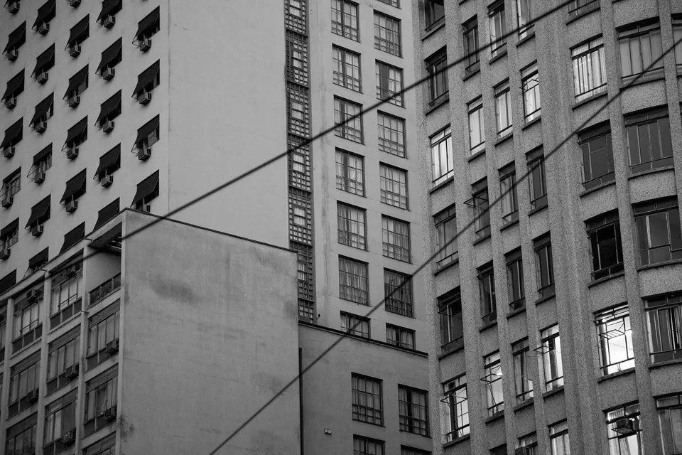 Uma foto em preto e branco de uma fileira de edifícios altos