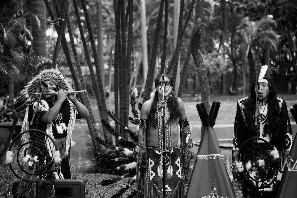 Um grupo de nativos americanos toca instrumentos em uma foto em preto e branco.