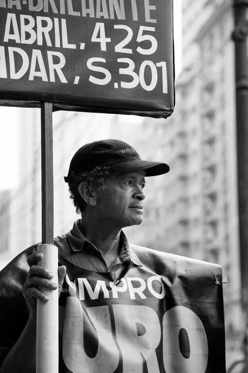 Um homem segurando uma placa que diz abril 425 dar s301