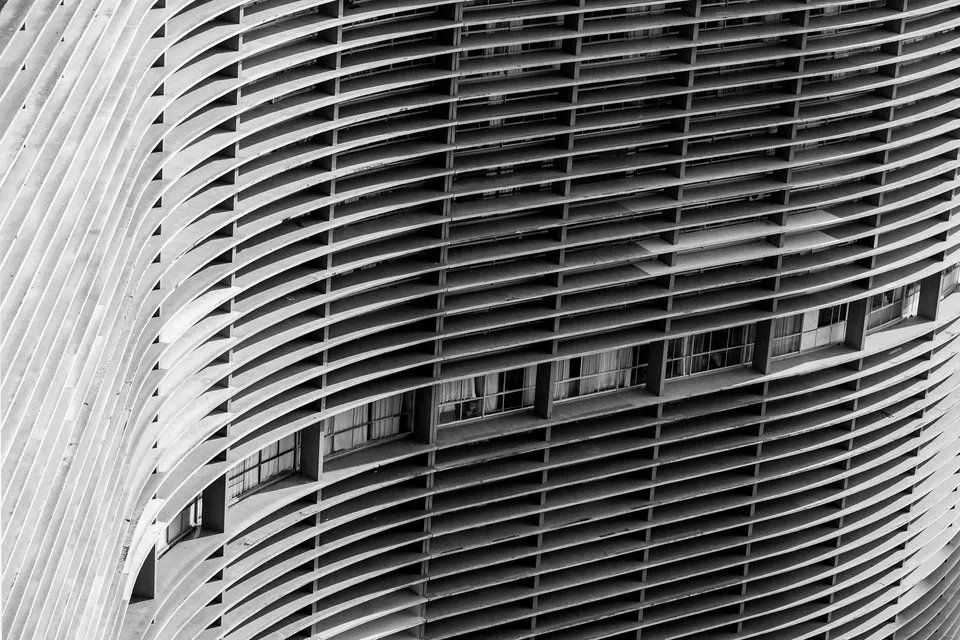 Uma foto em preto e branco de um prédio com muitas janelas.