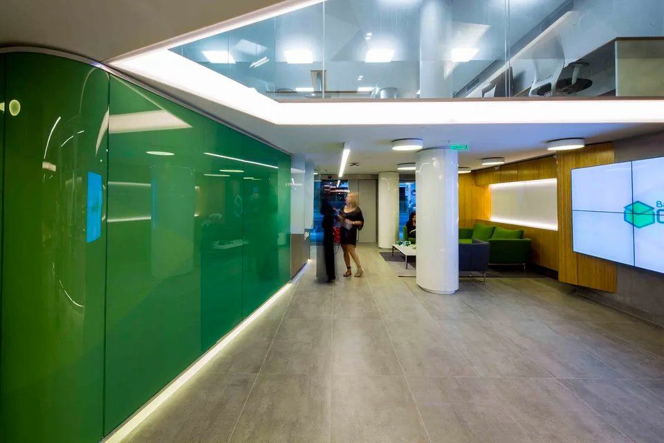 Uma mulher está parada em um corredor com uma parede verde.