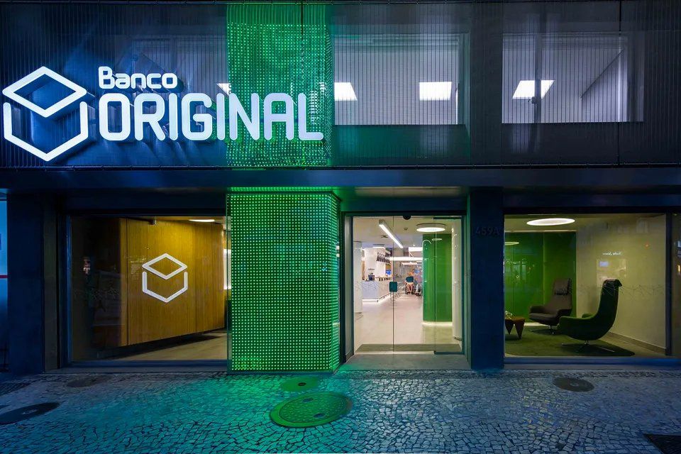 A frente de um prédio com uma placa verde que diz banco original.