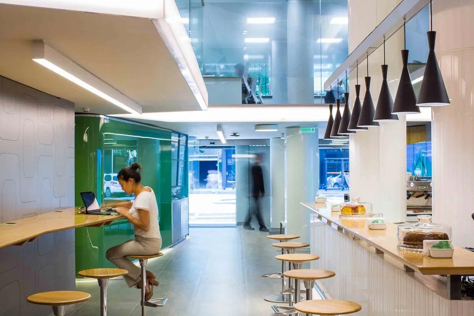 Uma mulher está sentada à mesa com um laptop em um restaurante.