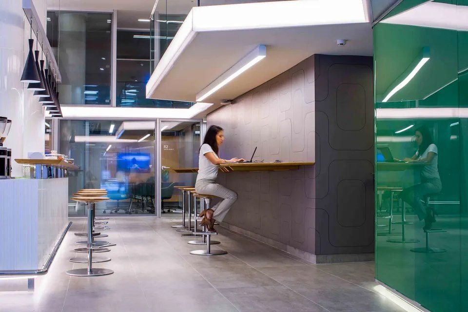 Uma mulher está sentada em um bar usando um laptop.