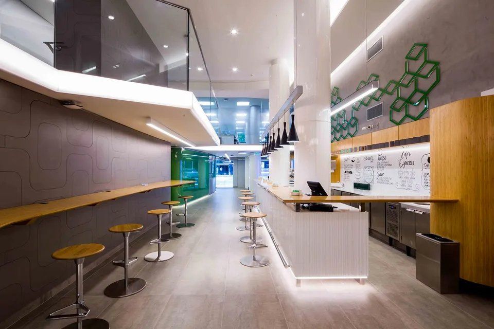 Um restaurante com mesas e bancos e um balcão