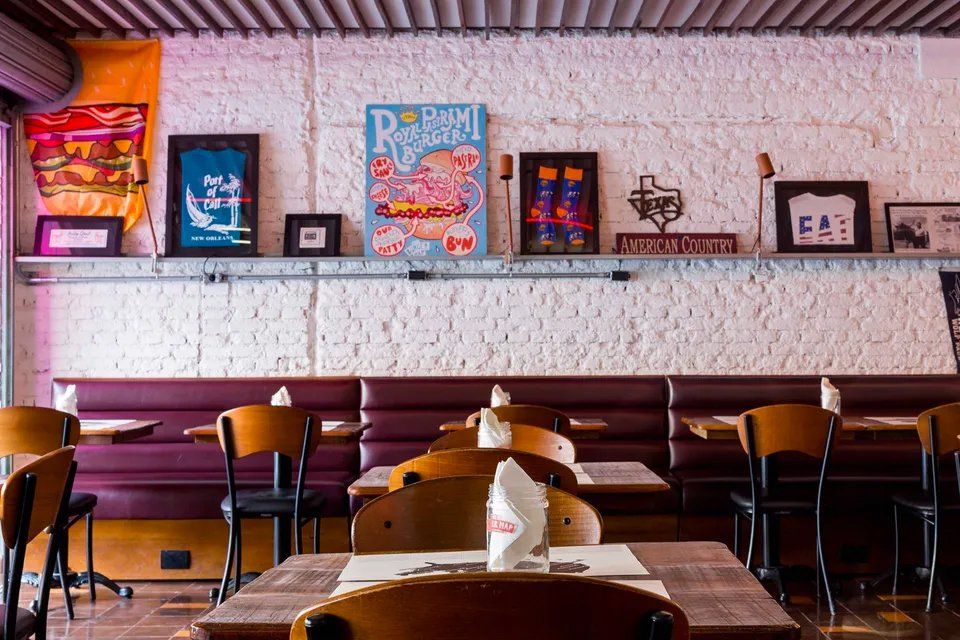 Um restaurante com mesas e cadeiras e uma parede de tijolos.