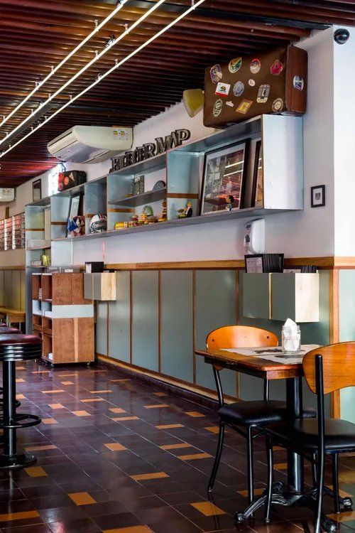 Um restaurante com mesas e cadeiras e uma mala na parede