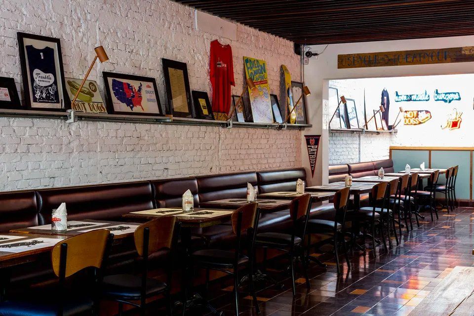 Um restaurante com mesas e cadeiras e pranchas de surf na parede