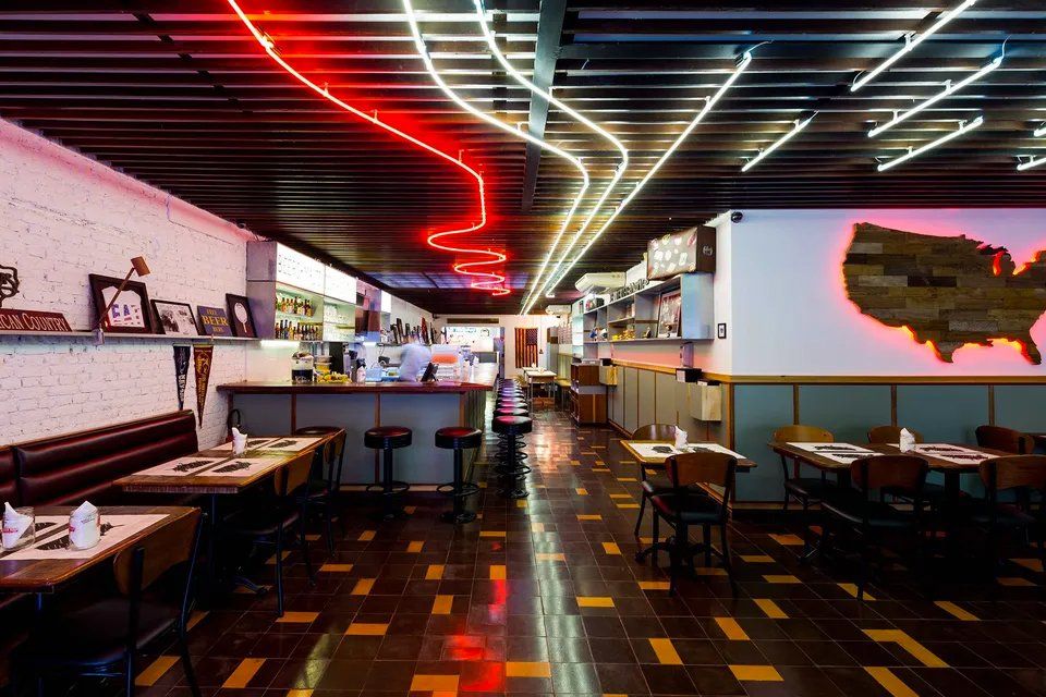 Um restaurante com mesas e cadeiras e um mapa dos Estados Unidos na parede.