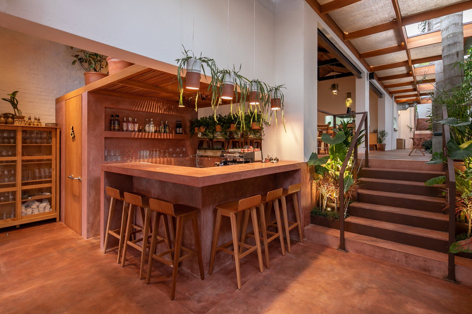 Um restaurante com um longo bar de madeira e bancos.