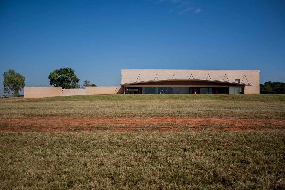 Um grande edifício está situado no meio de um campo gramado.