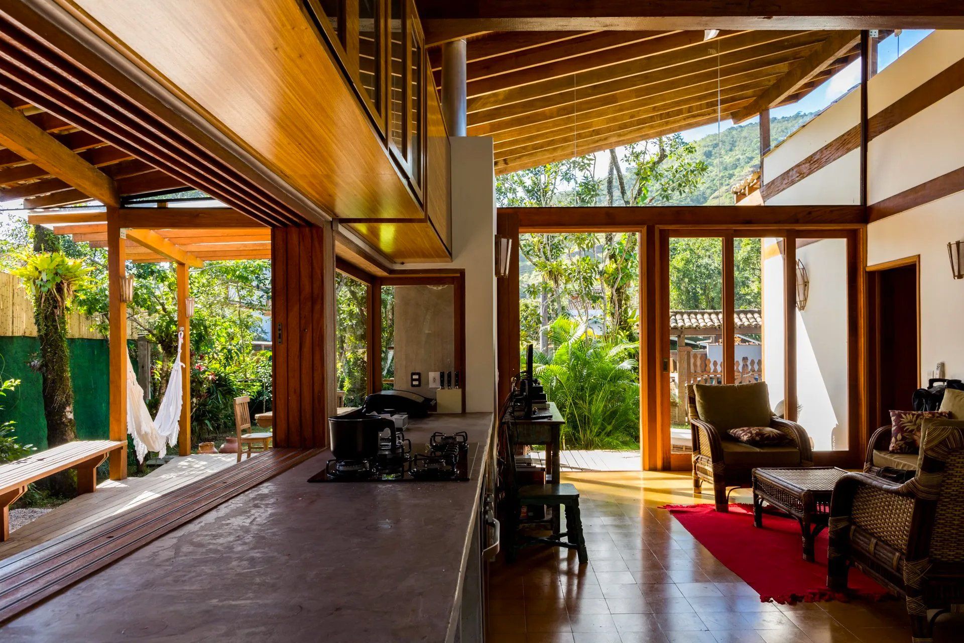 Uma cozinha e sala numa casa com muitas janelas.