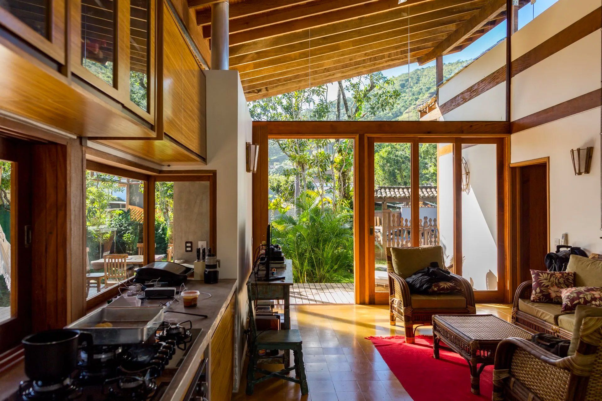 Uma cozinha e sala numa casa com muitas janelas.