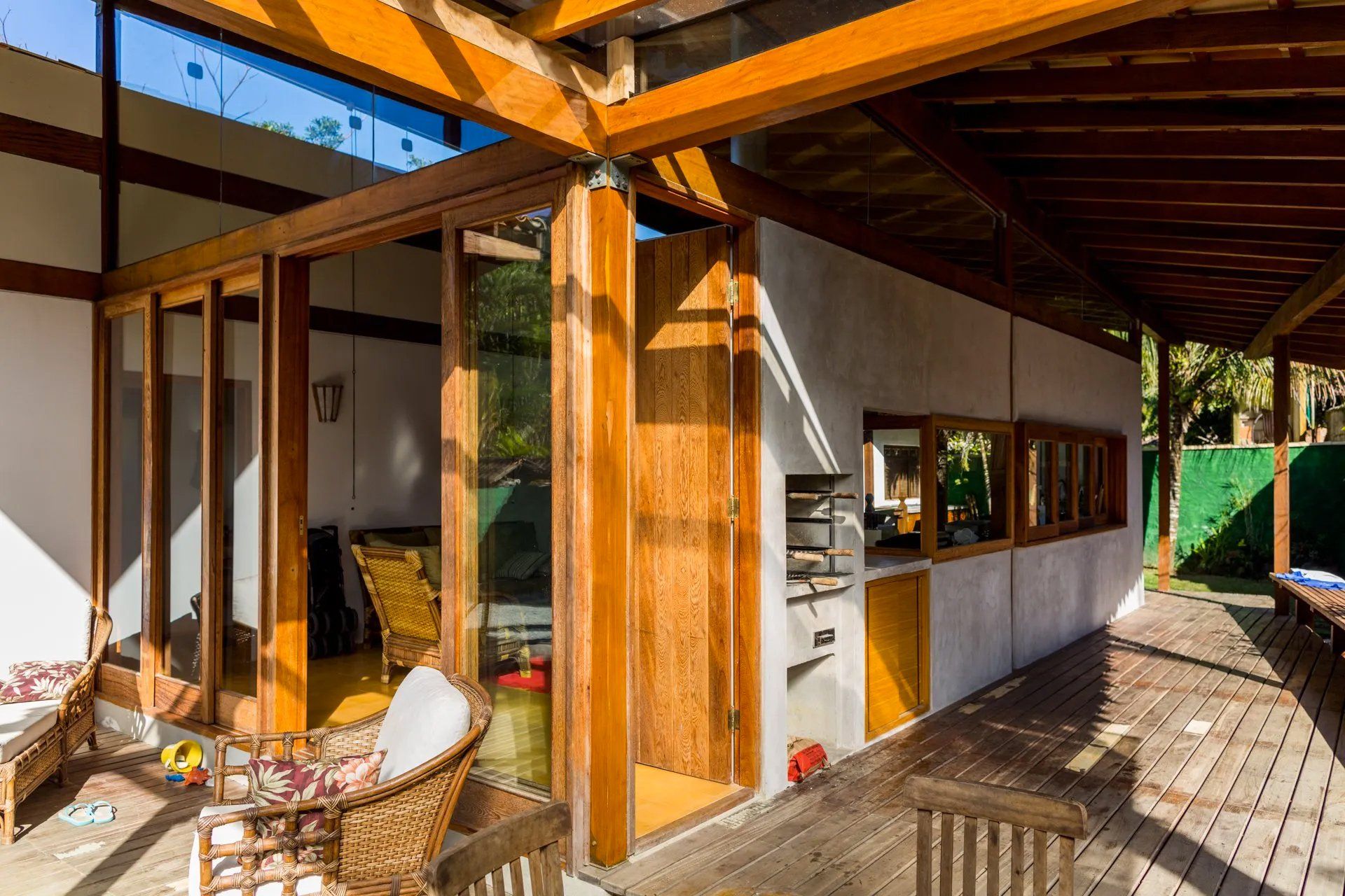 Uma casa com muitas janelas e deck de madeira.