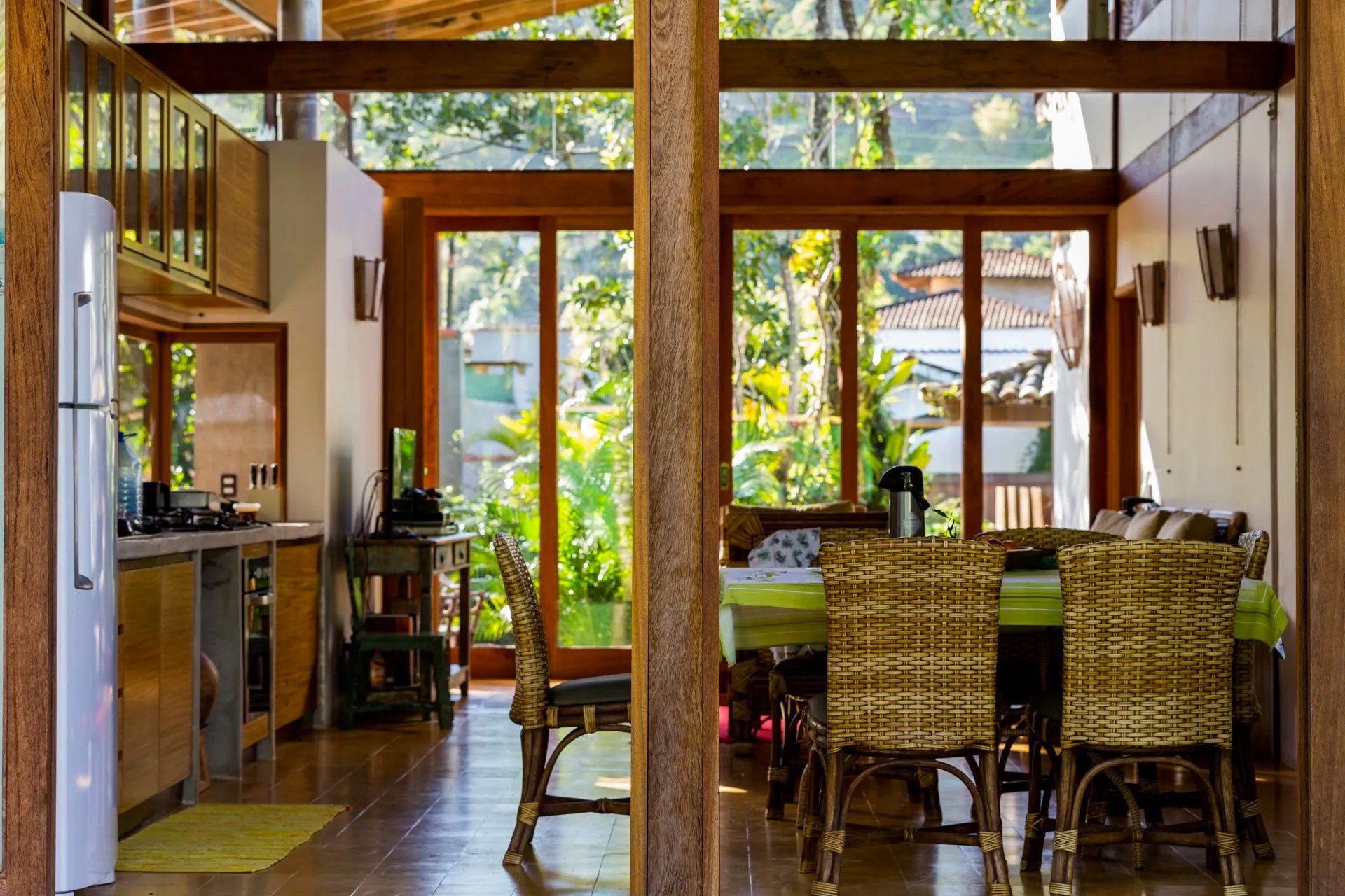 Uma cozinha e sala de jantar numa casa com muitas janelas.
