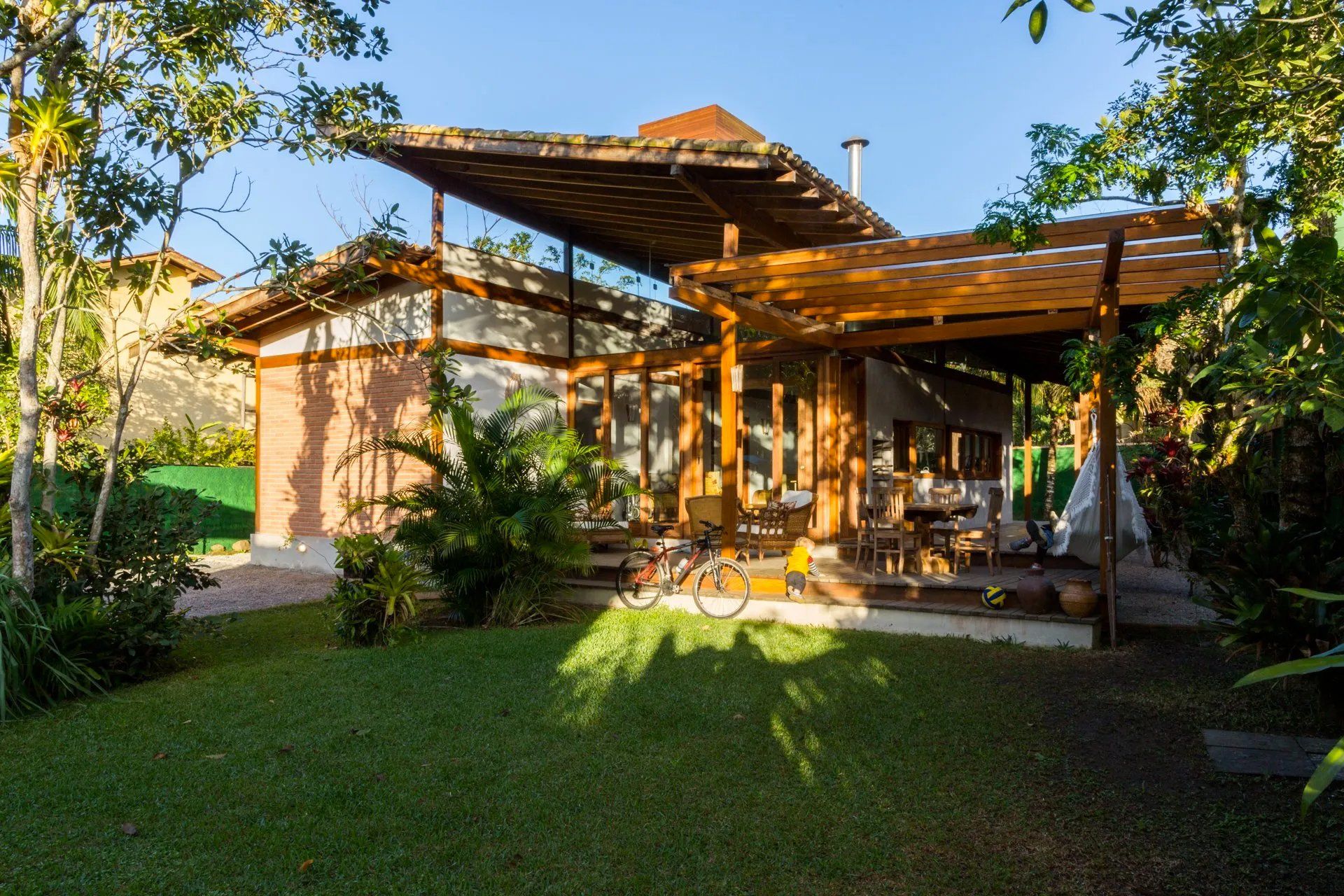 Uma pequena casa de madeira com pérgula no quintal