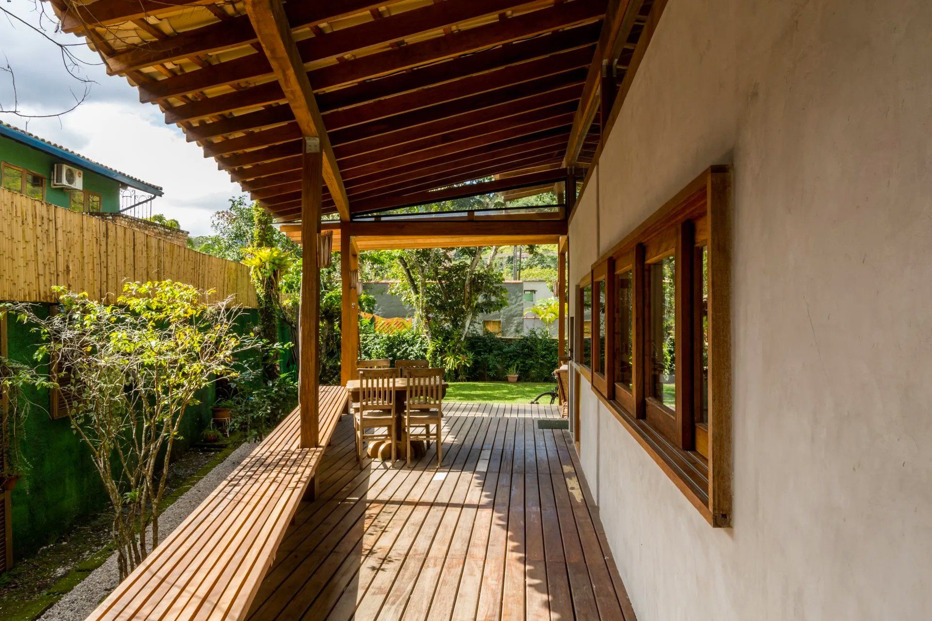 Há um deck de madeira com mesa e cadeiras.